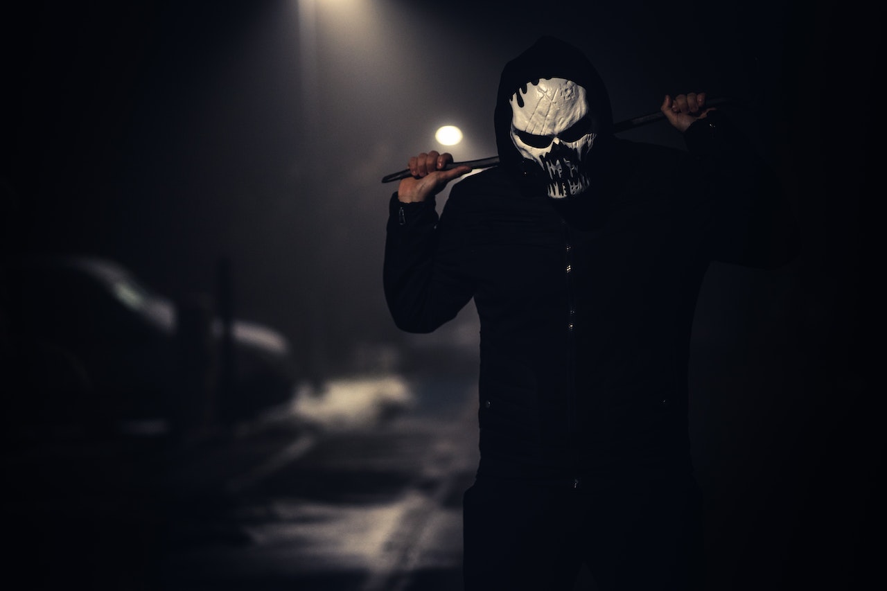 Erson in Black Jacket Wearing White Scary Mask